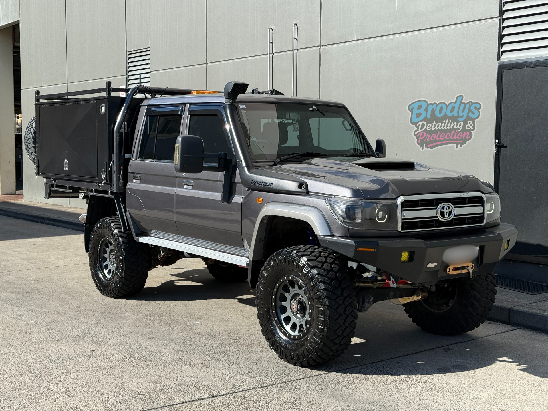 Grey Toyota Land Cruiser truck with off-road modifications, parked outside a building. — Brody’s Car Detailing In Tamworth, NSW