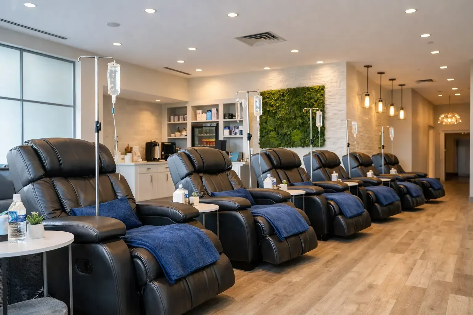 Modern spa lounge with black recliner chairs, blue blankets, and warm lighting
