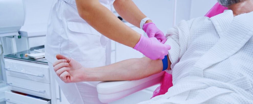 Medical professional administering an injection to a patient lying on a clinic bed