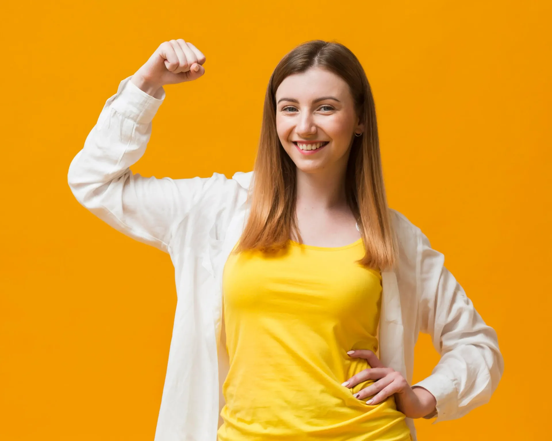 Smiling woman in yellow shirt and white cardigan flexing against a bright orange background