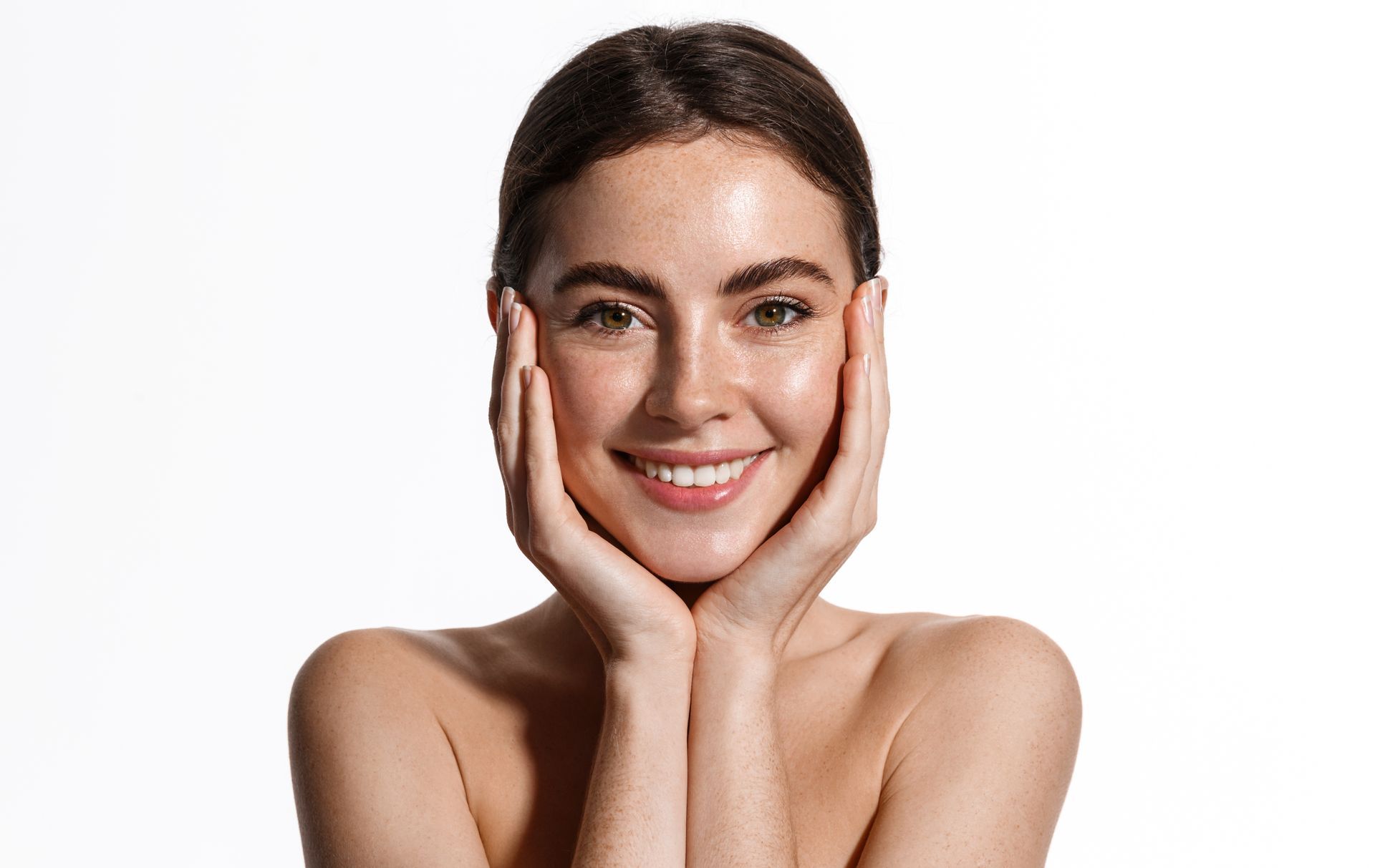 Smiling woman with hands on her cheeks against a white background