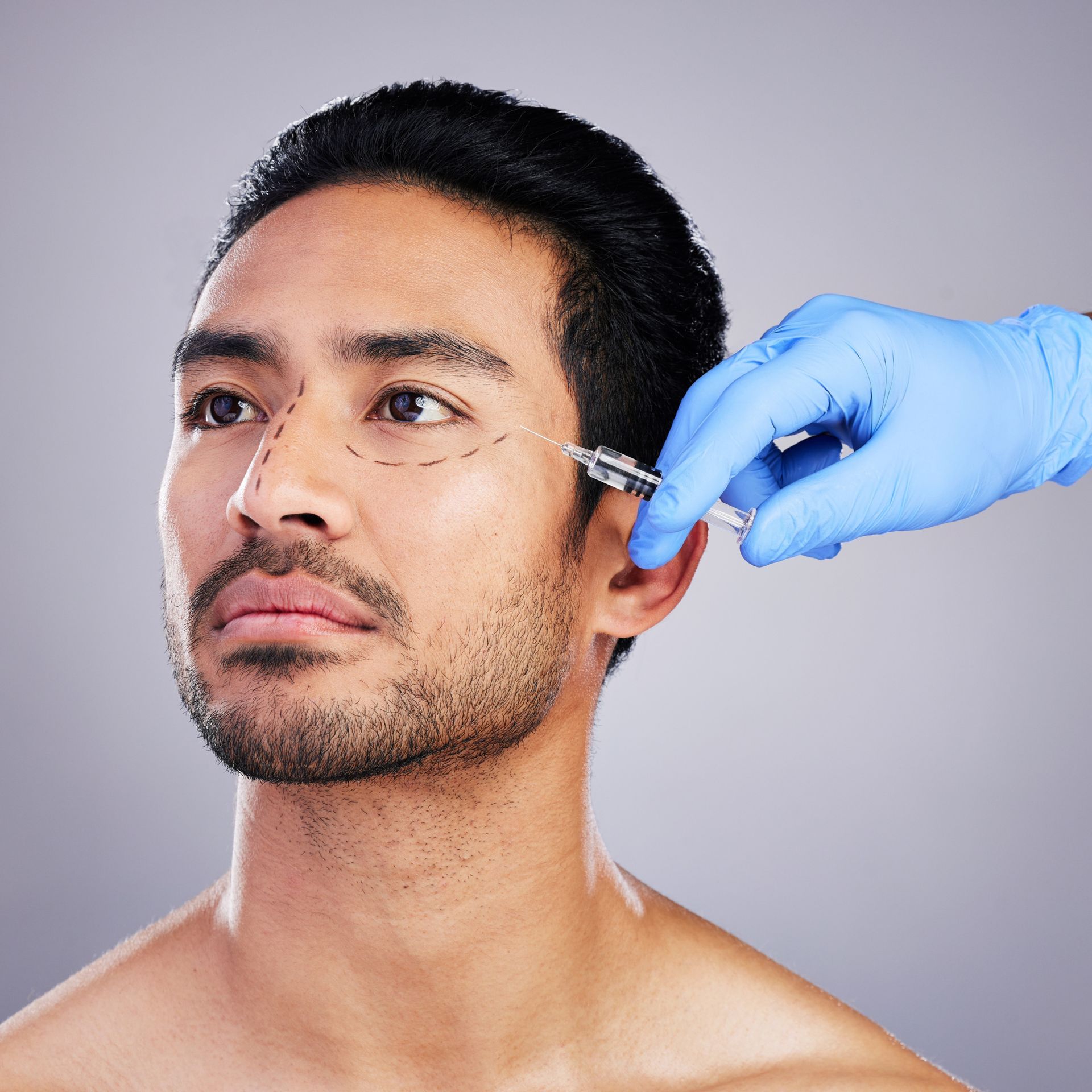 Man receiving an injection near his eye; lines on his face, blue-gloved hand holds syringe, neutral background.