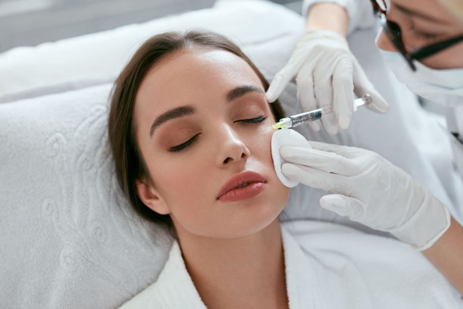 Person receiving facial injection in a medical setting; close-up of a woman's face.