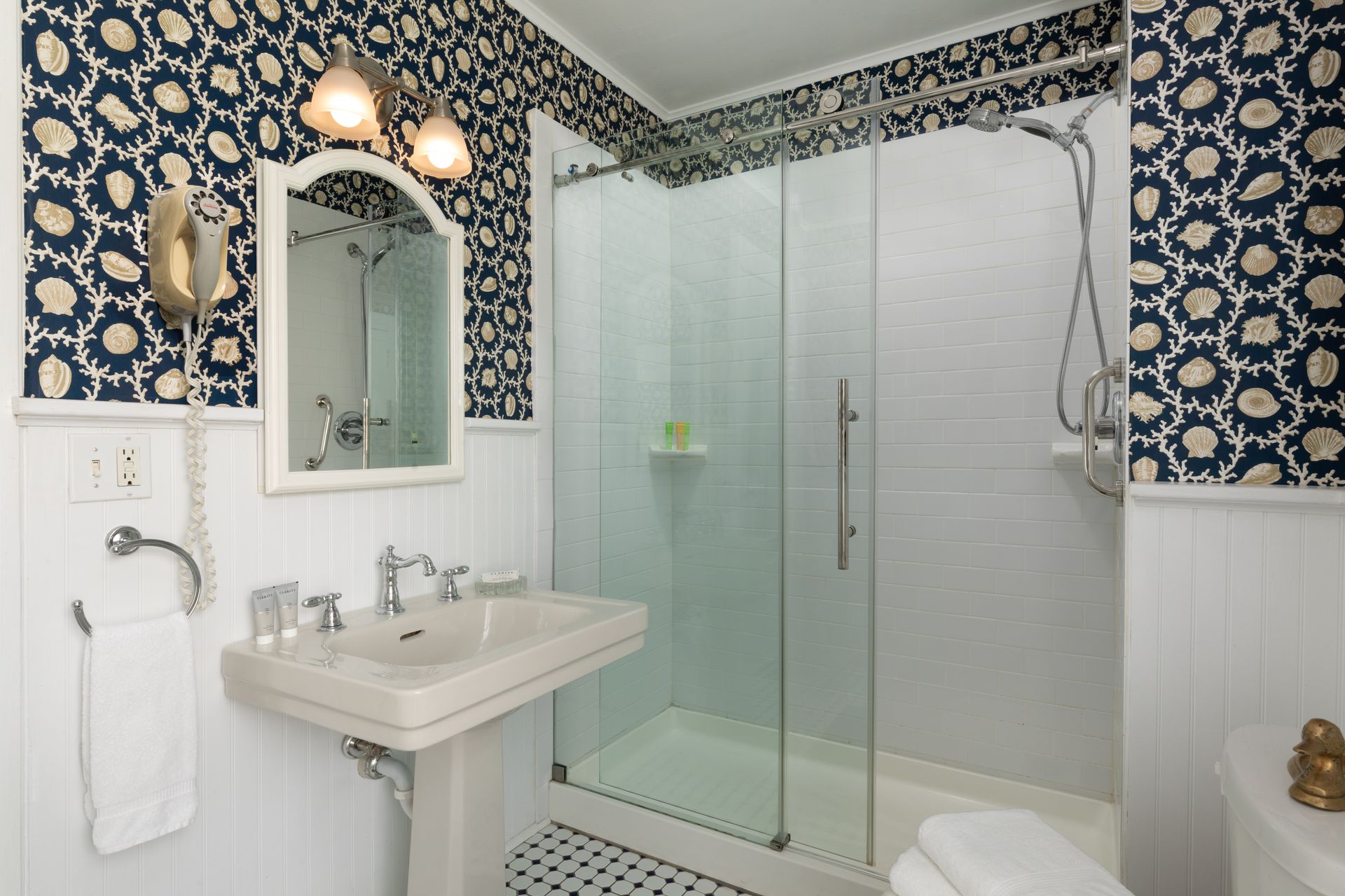 A bathroom with a sink and a walk in shower