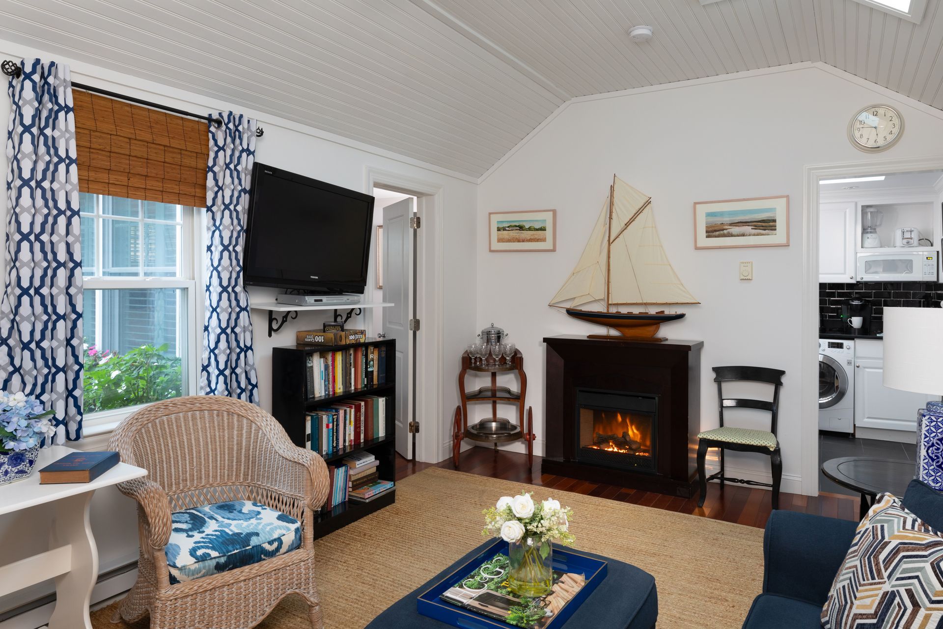 A living room with a fireplace and a sailboat on the mantle