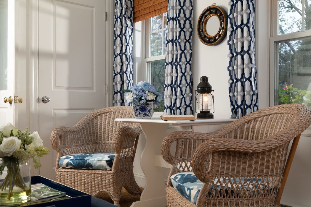 A living room with two wicker chairs and a table.