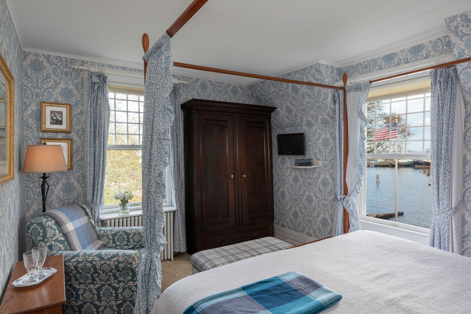 A bedroom with a canopy bed and a chair