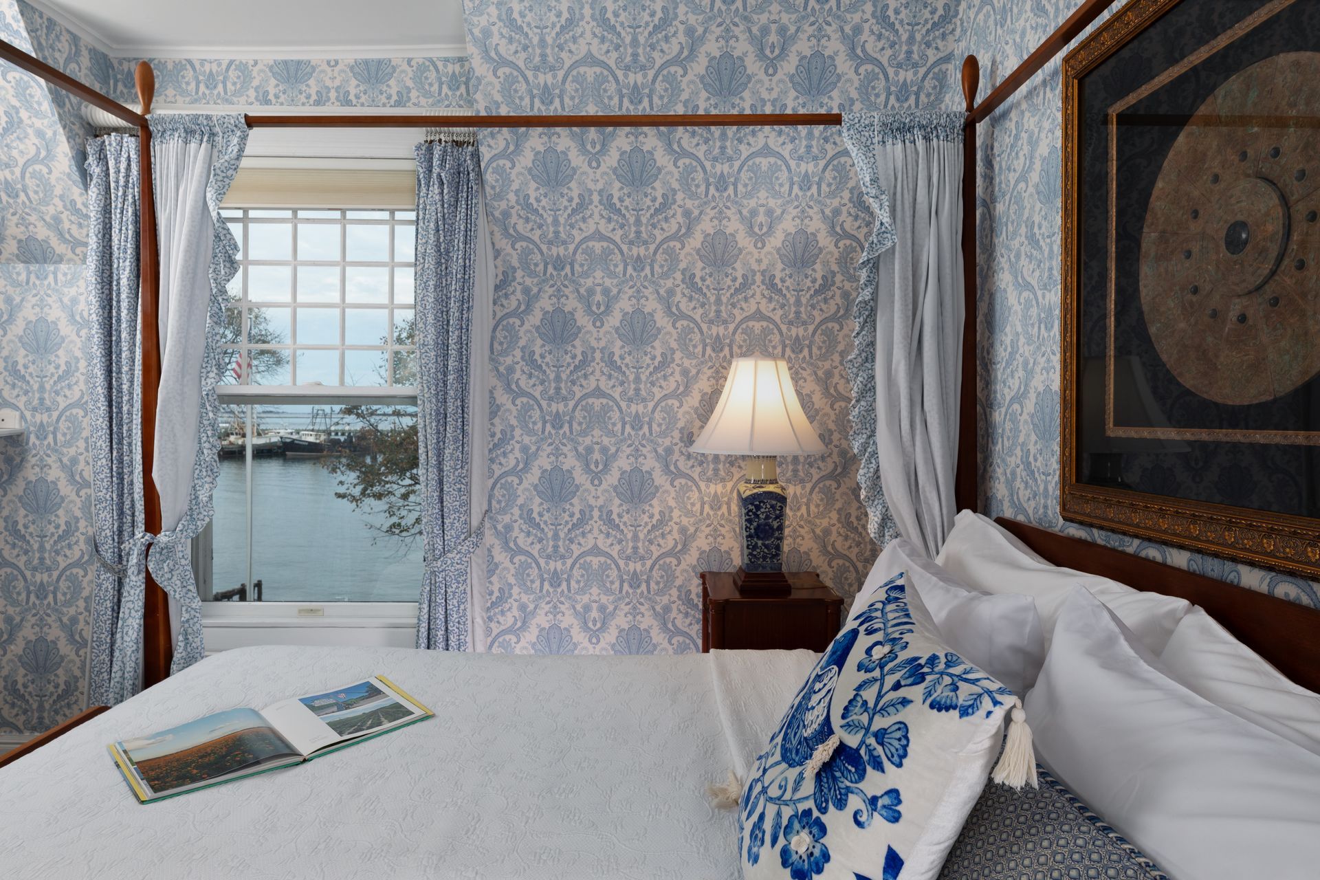 A bedroom with a four poster bed and a window