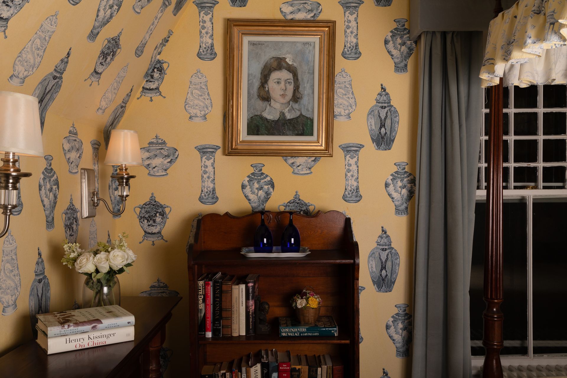 A room with a bookshelf and a painting on the wall