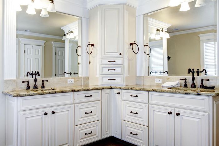 Bright white bathroom vanity with double sinks, large mirror, and granite countertop