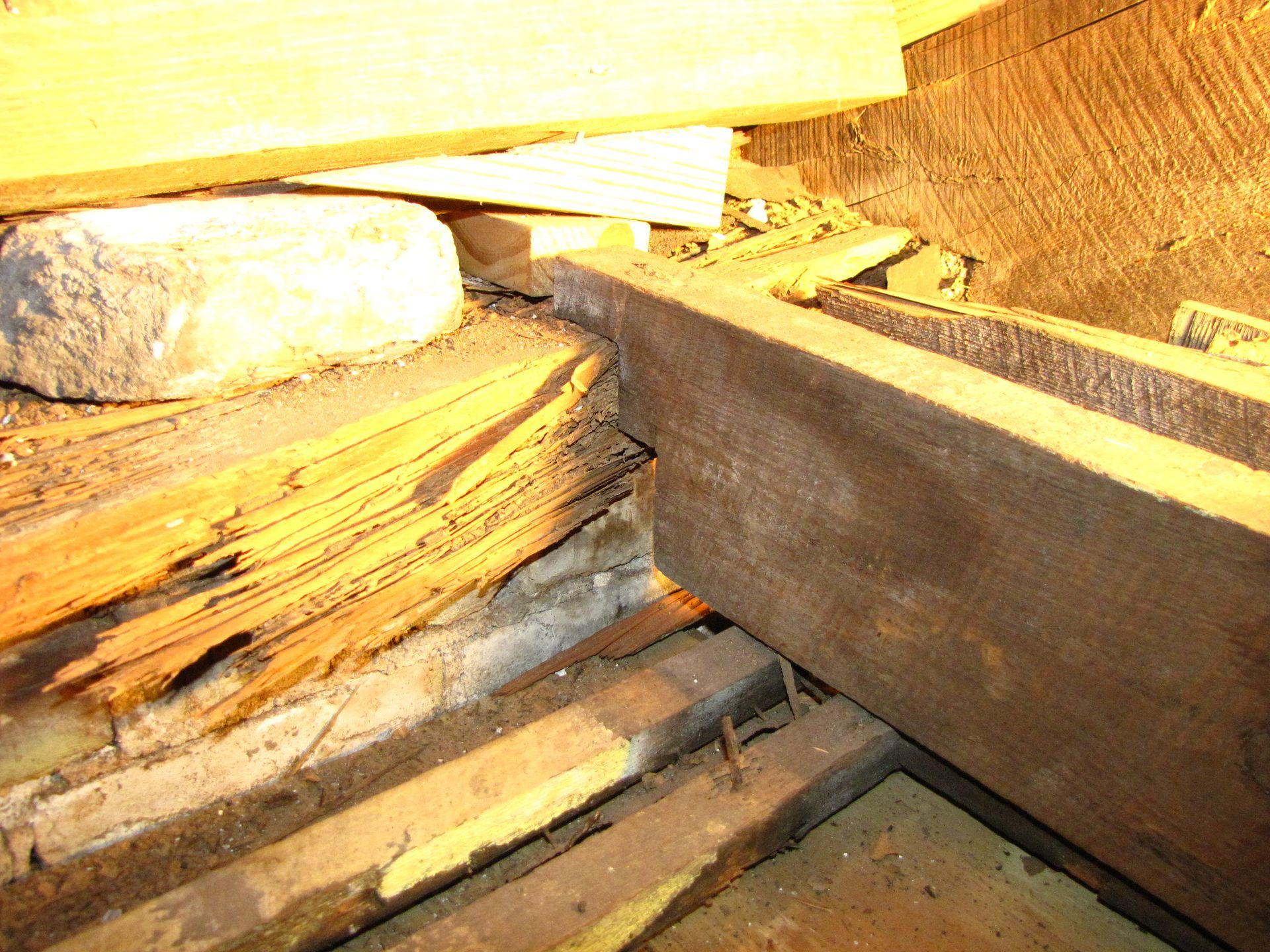Close-up of stacked wooden beams and logs in a dimly lit storage or workshop area.