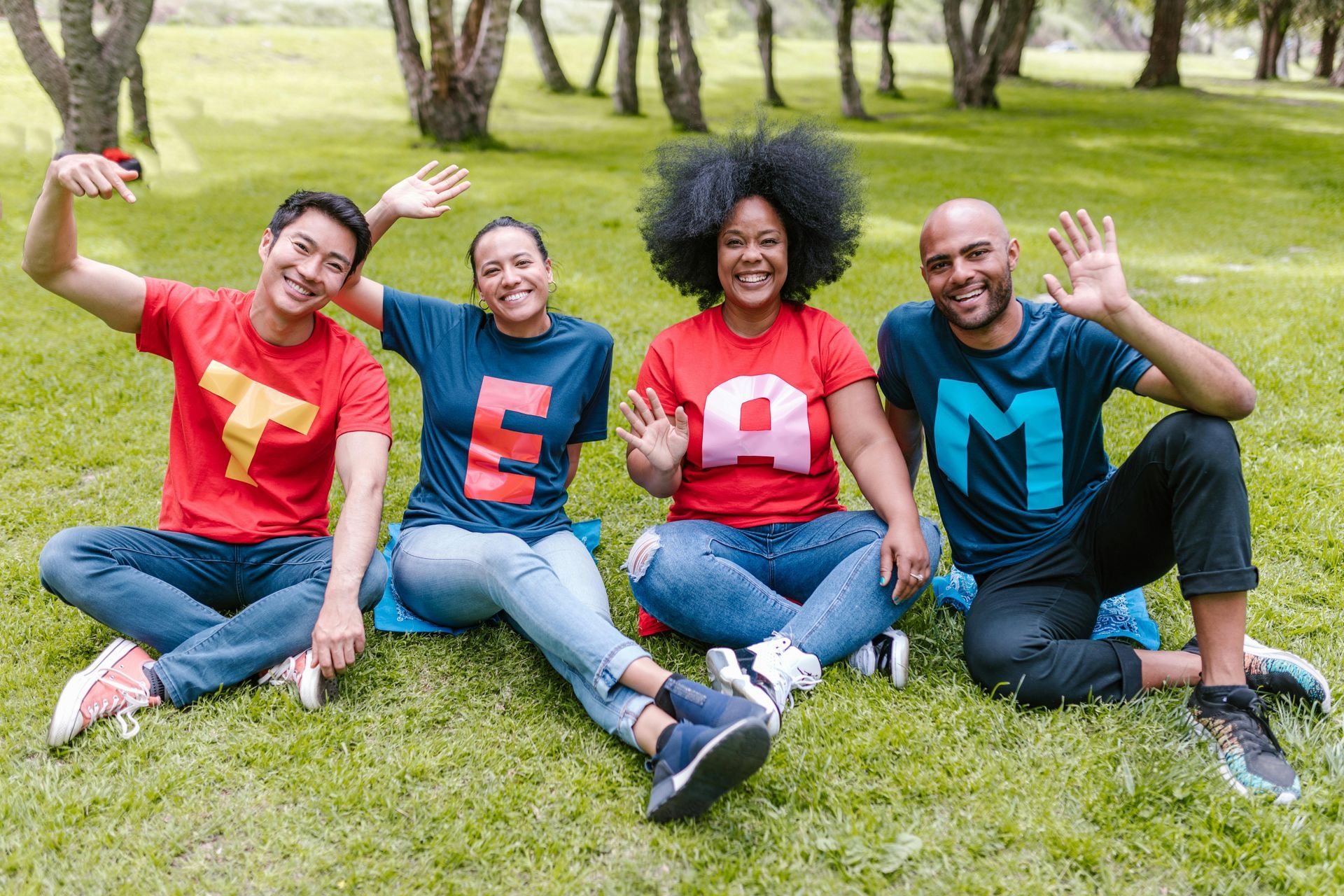 Four people in colorful shirts spelling 