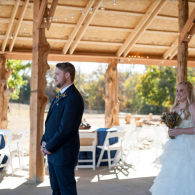 Bride and groom standing in a rustic wedding venue during the ceremony