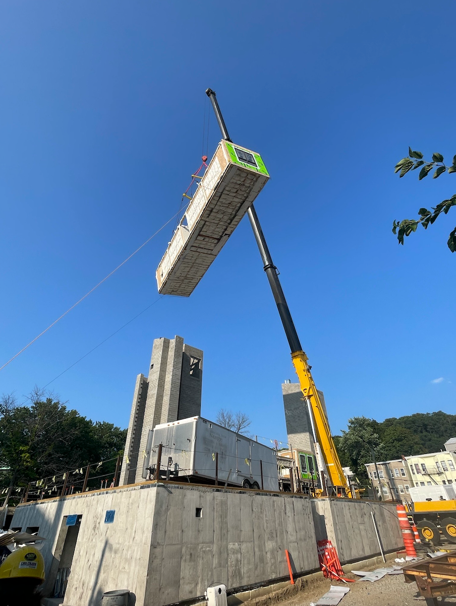 A crane is lifting a container into the air.