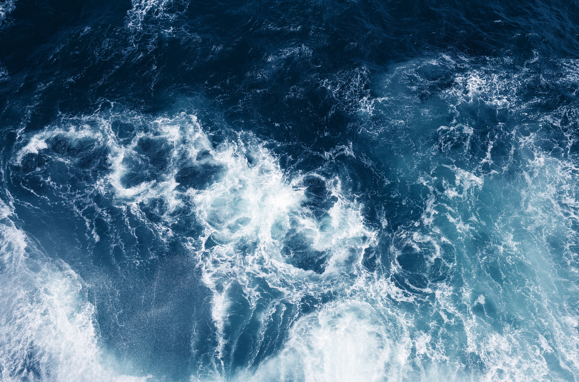 A close up of a body of water with waves and foam
