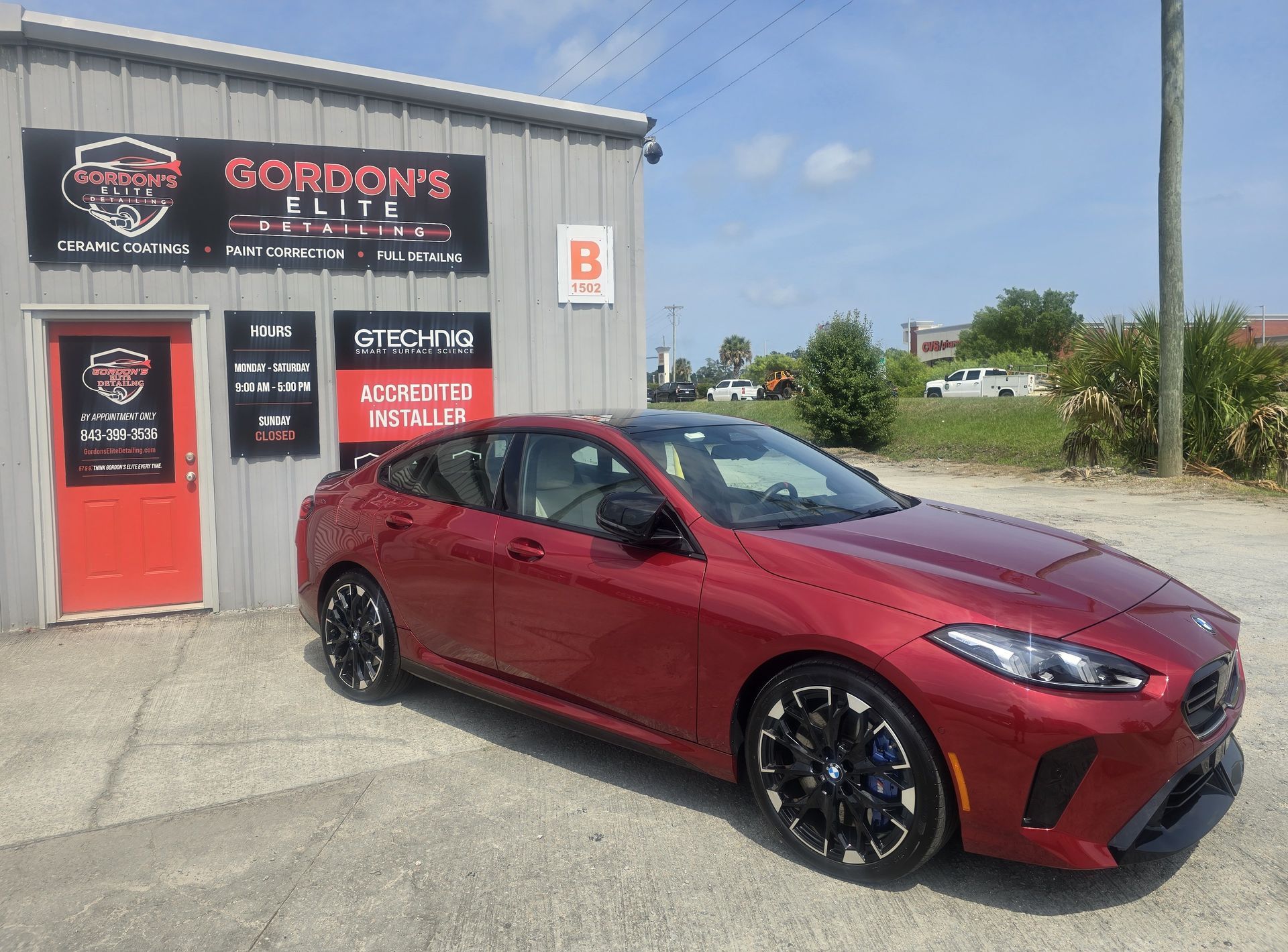 A car is parked in front of a building that says gordon 's elite