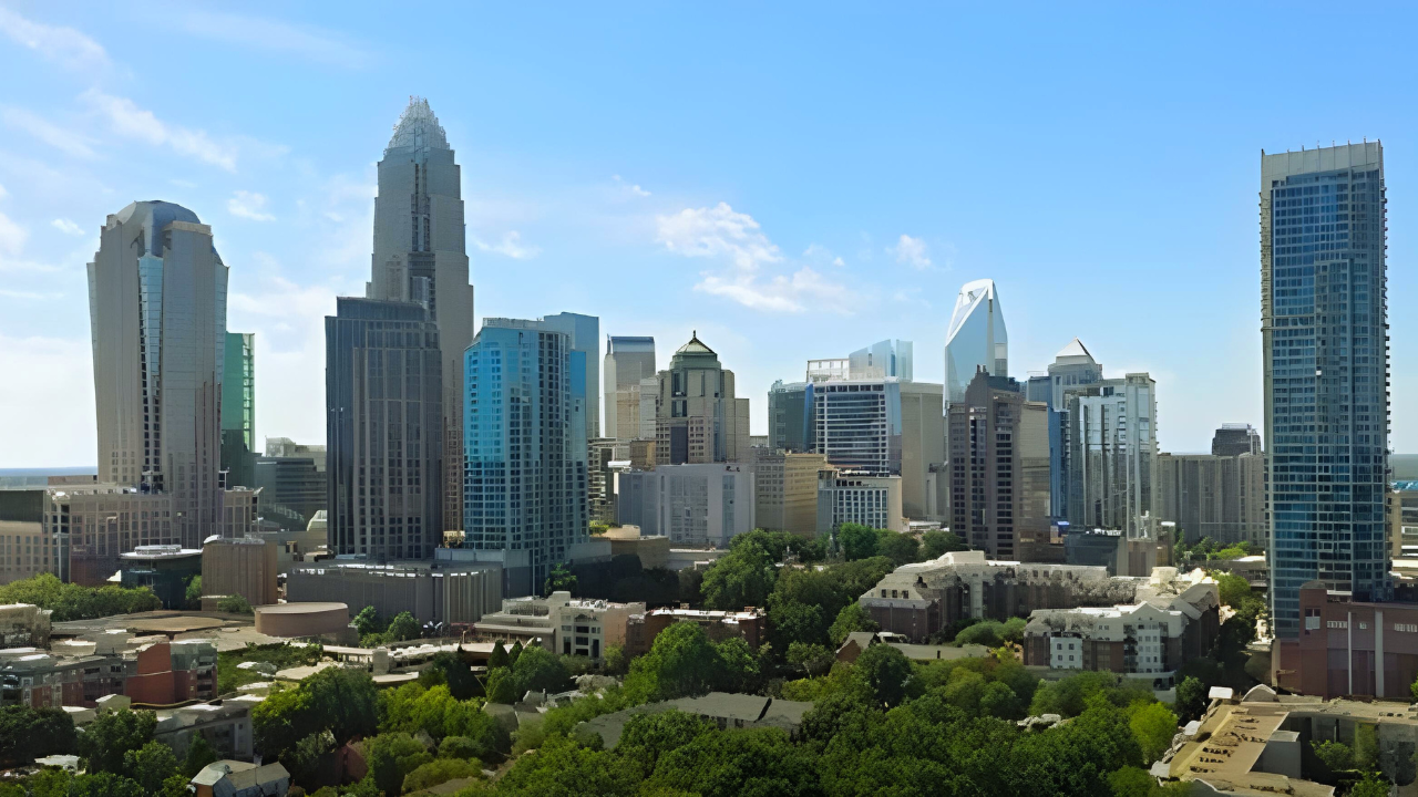 Charlotte, North Carolina skyline with tall buildings against a clear blue sky.