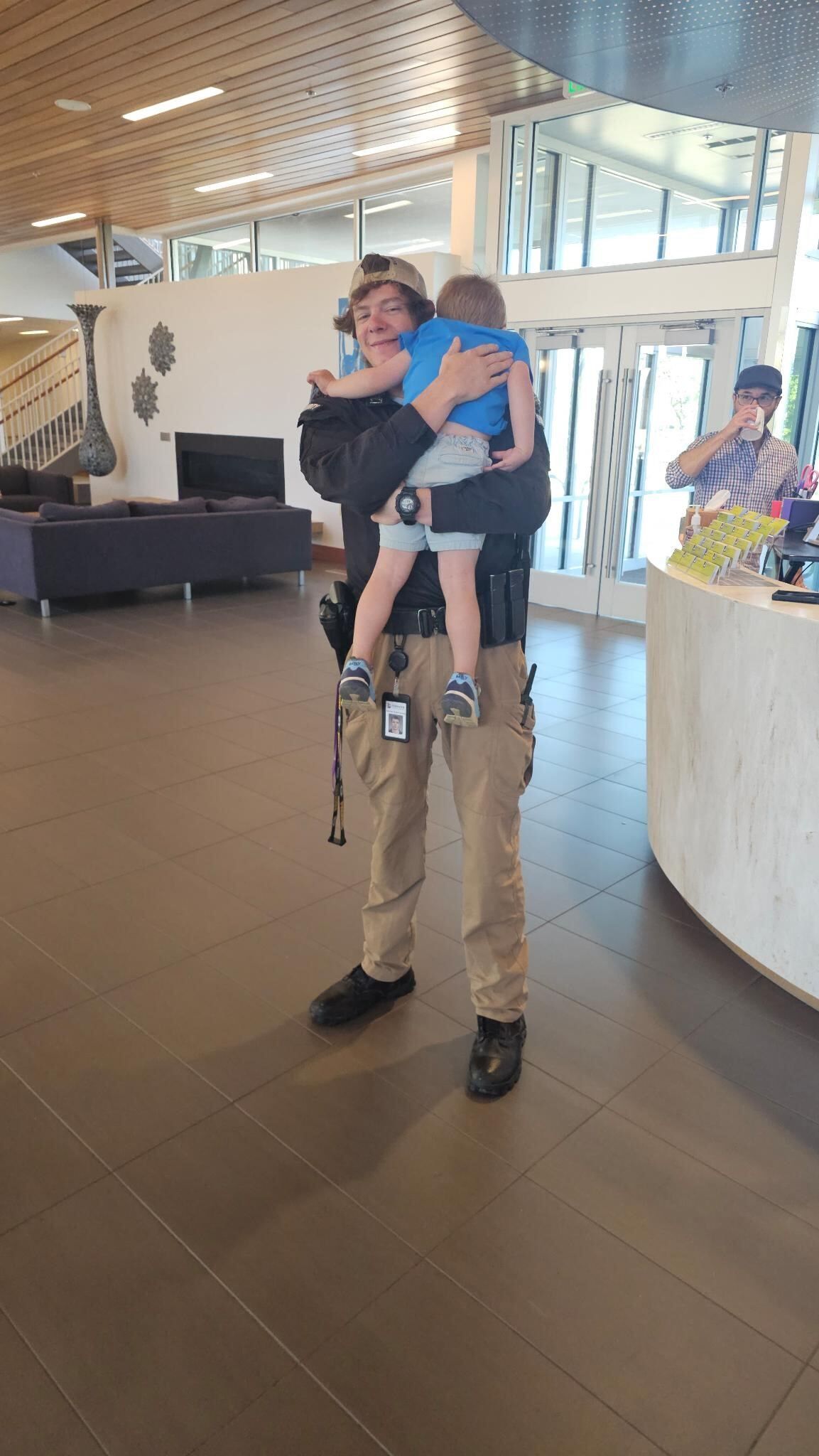 A man is holding a child in his arms in a lobby.
