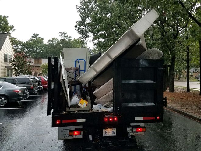 A dump truck is loaded with a lot of furniture