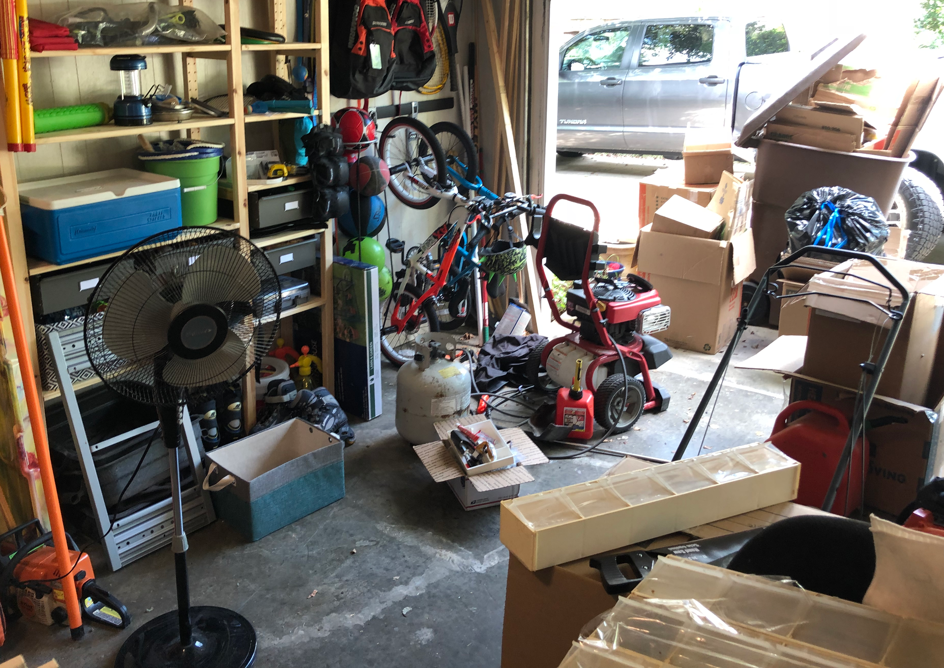 A garage filled with lots of boxes and bicycles.