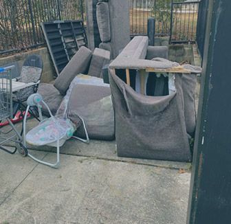 A pile of trash is sitting in front of a house.