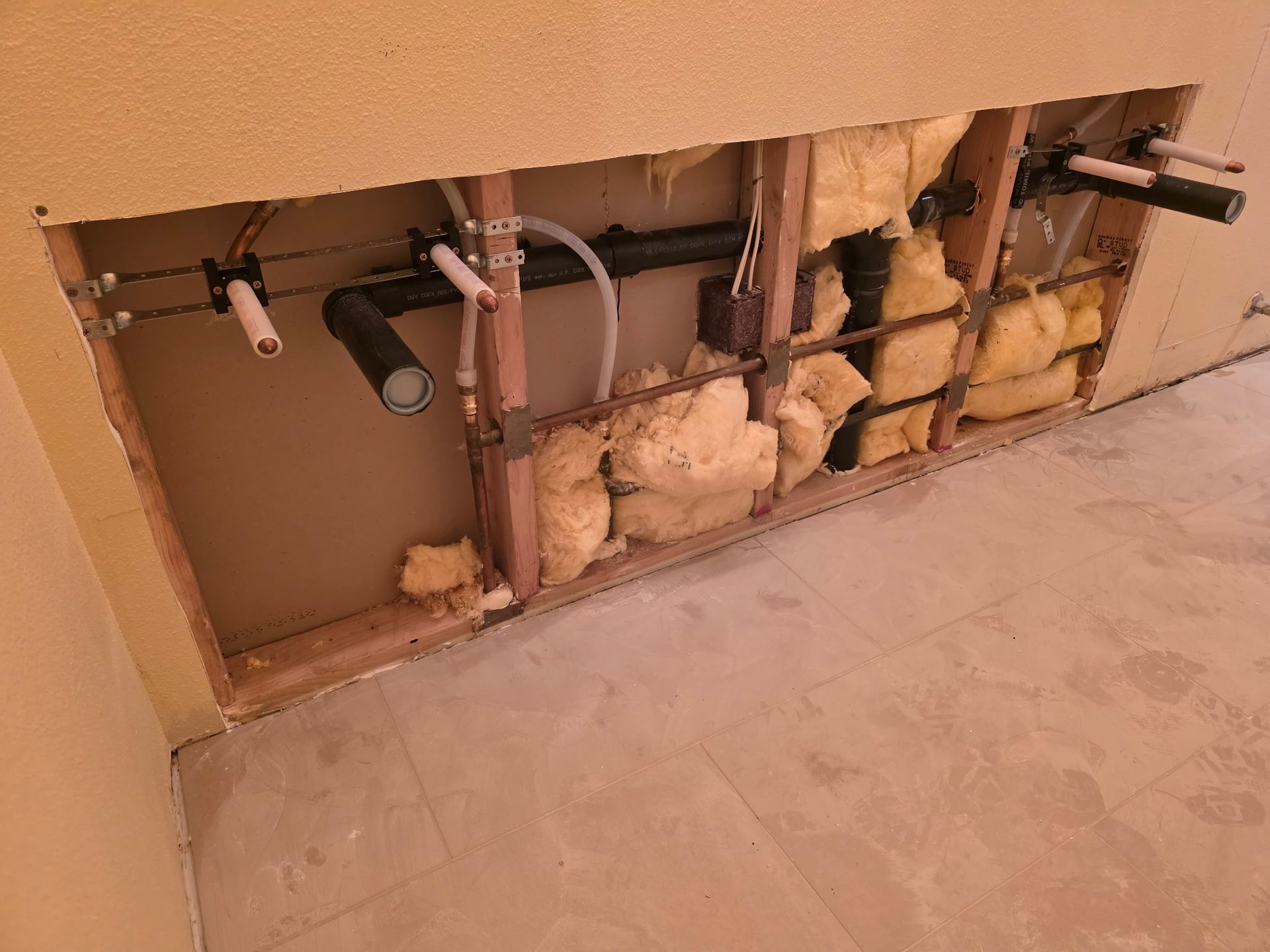 Gray pipes run along a concrete wall, turning sharply at the corner.