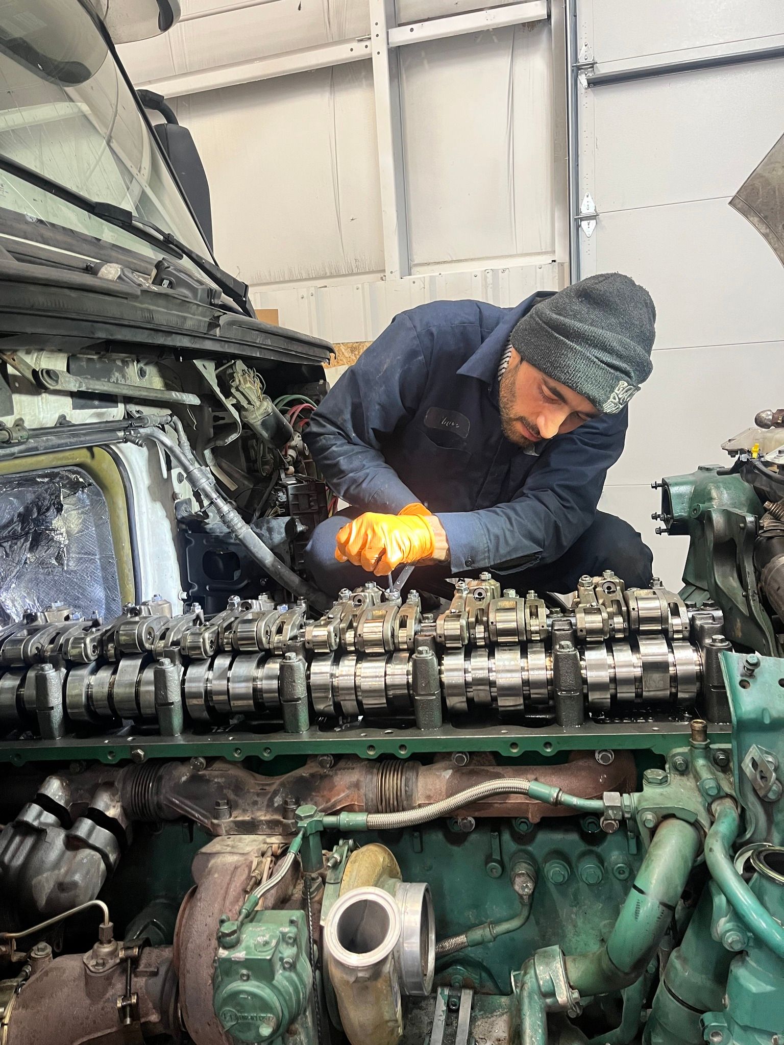 A man is working on a large engine in a garage.