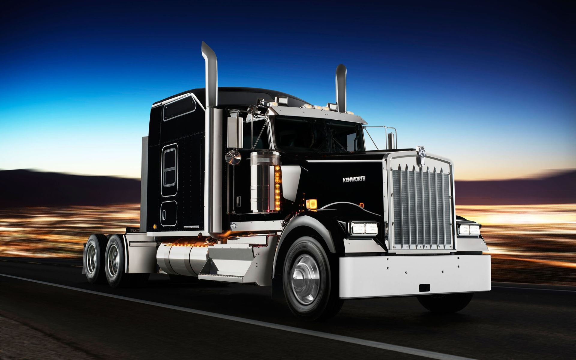 A black and white semi truck is driving down a road