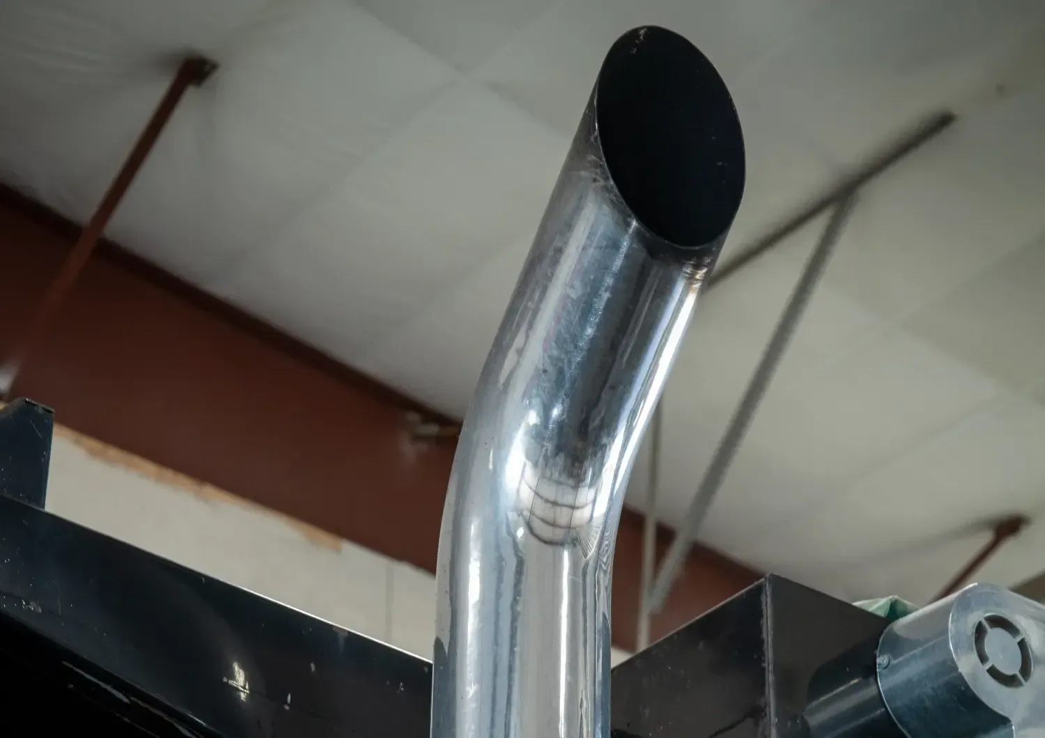 A close up of a stainless steel pipe with a black cap