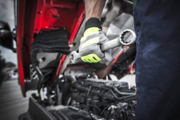 A man is working on a car engine with a wrench.