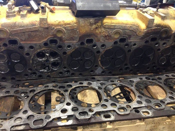 A close up of a cylinder head with a lot of holes in it