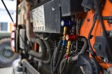 A close up of a tractor engine with a hose attached to it