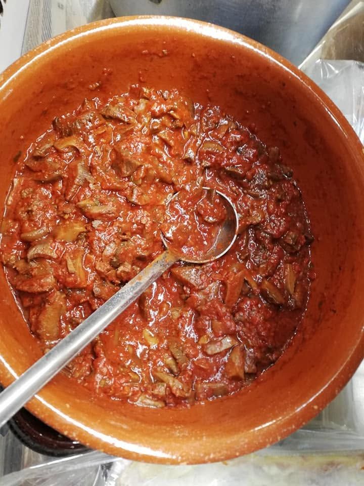 Ciotola di stufato o salsa rossa e densa con un cucchiaio di metallo