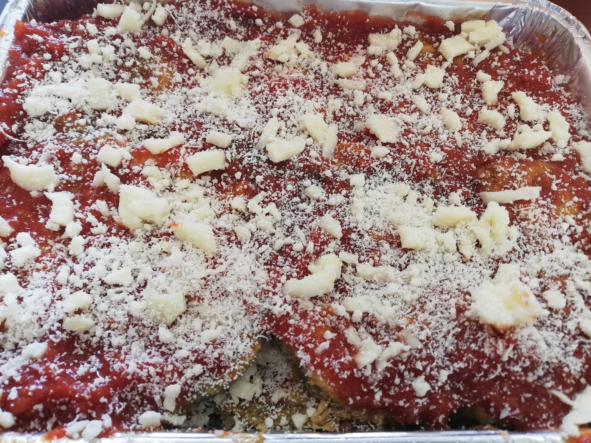 Vassoio di dessert dalla superficie rossa, spolverizzato con zucchero a velo e briciole di formaggio o streusel