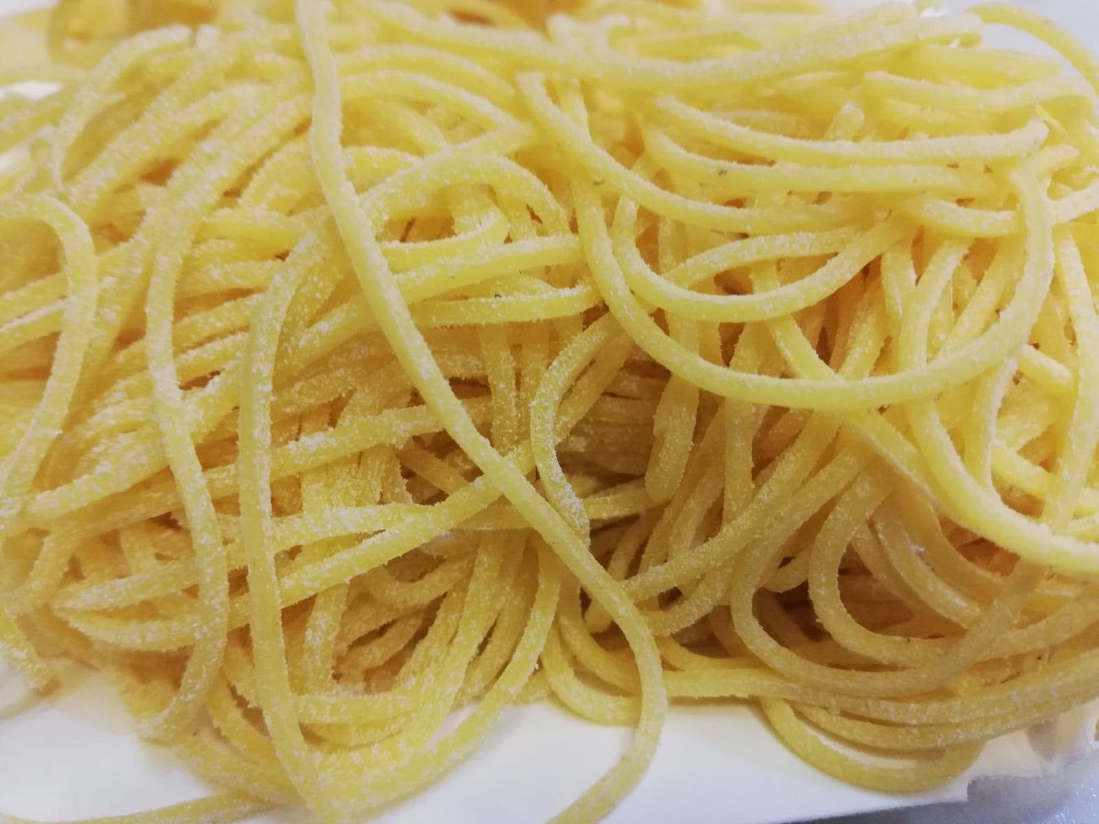 Primo piano di un piatto di spaghetti gialli al naturale