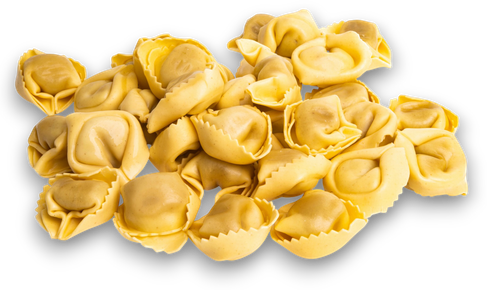 Mucchio di tortellini gialli crudi su sfondo bianco