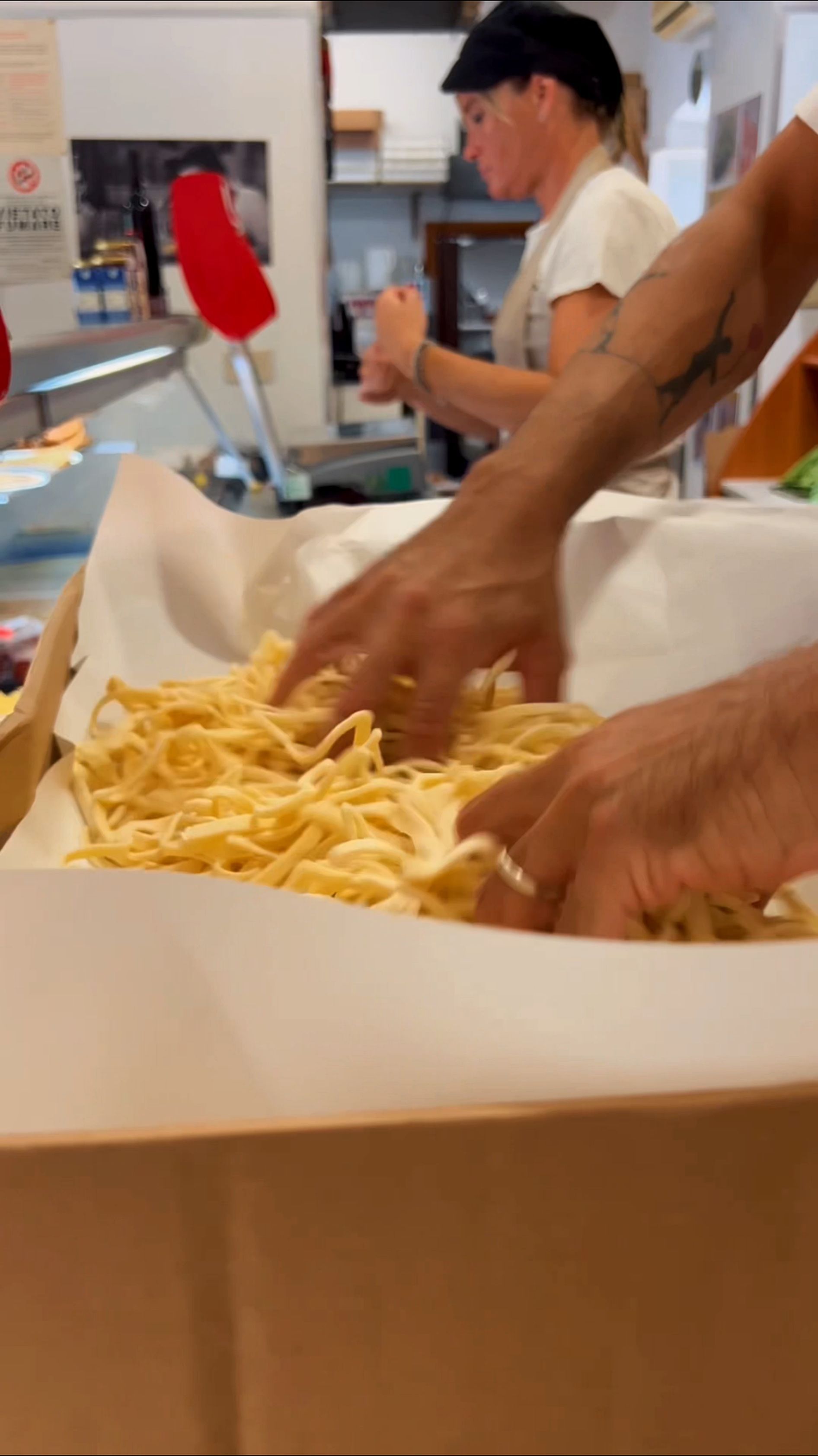 Mani che prendono tortilla chips da una scatola di cartone nell’area del bancone di un ristorante