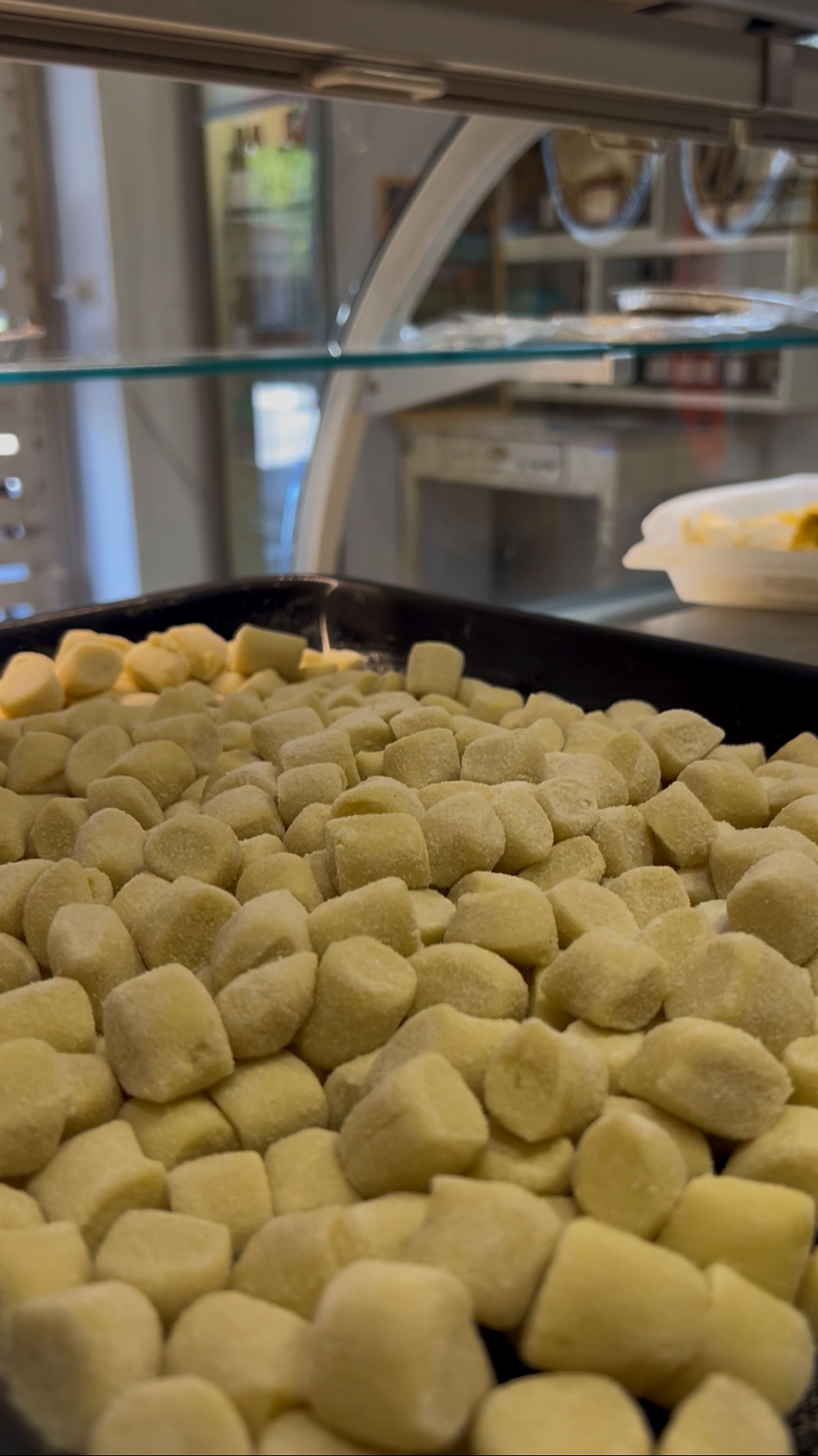 Vassoio di gnocchi crudi in un'area di preparazione di una cucina o di una panetteria