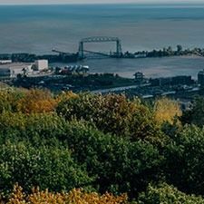 View of Duluth, Minnesota, with the Aerial Lift Bridge over Lake Superior, seen from a hillside with colorful autumn trees.