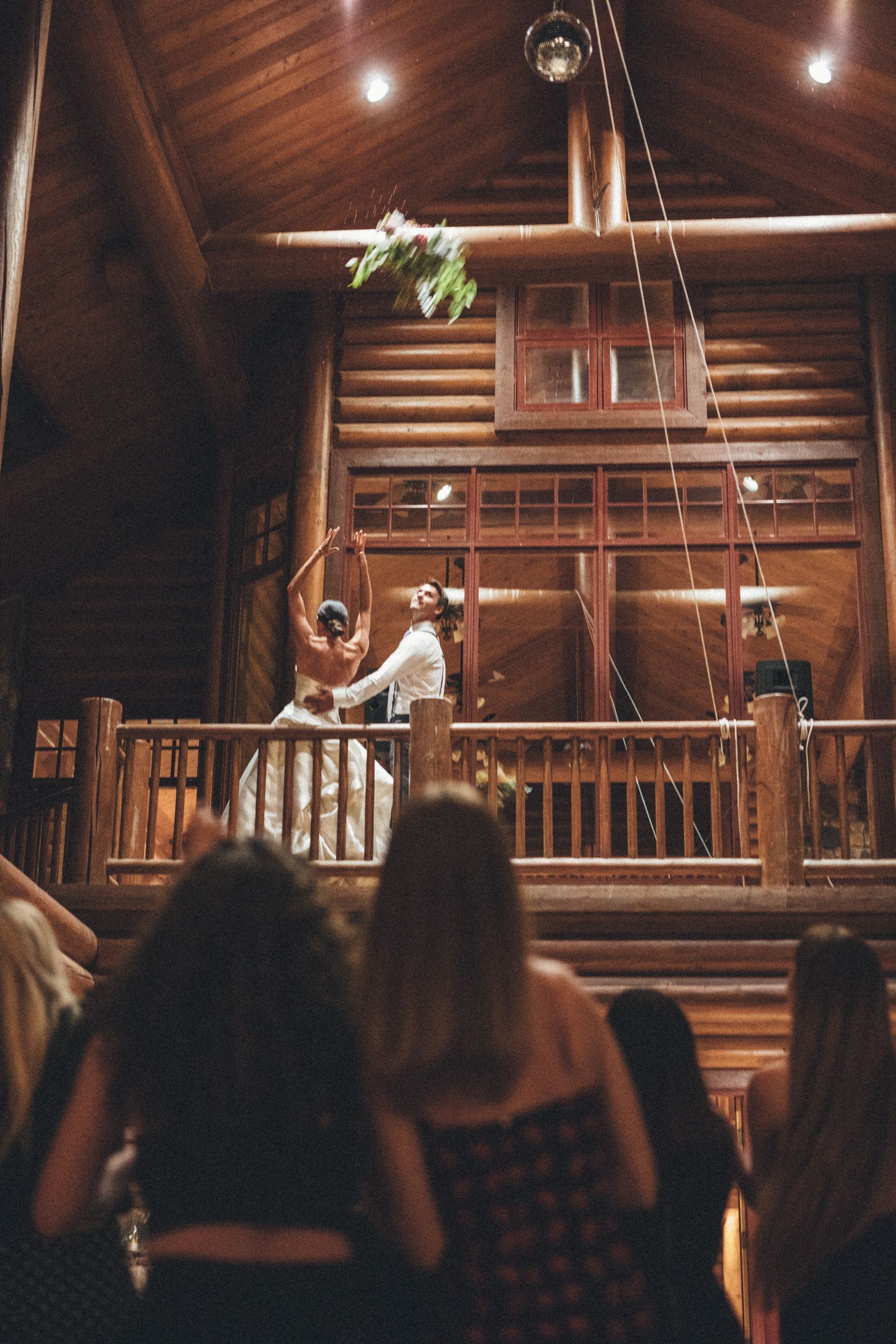 Wedding ceremony in a rustic wooden chapel, with bride and groom at the altar under warm lights.