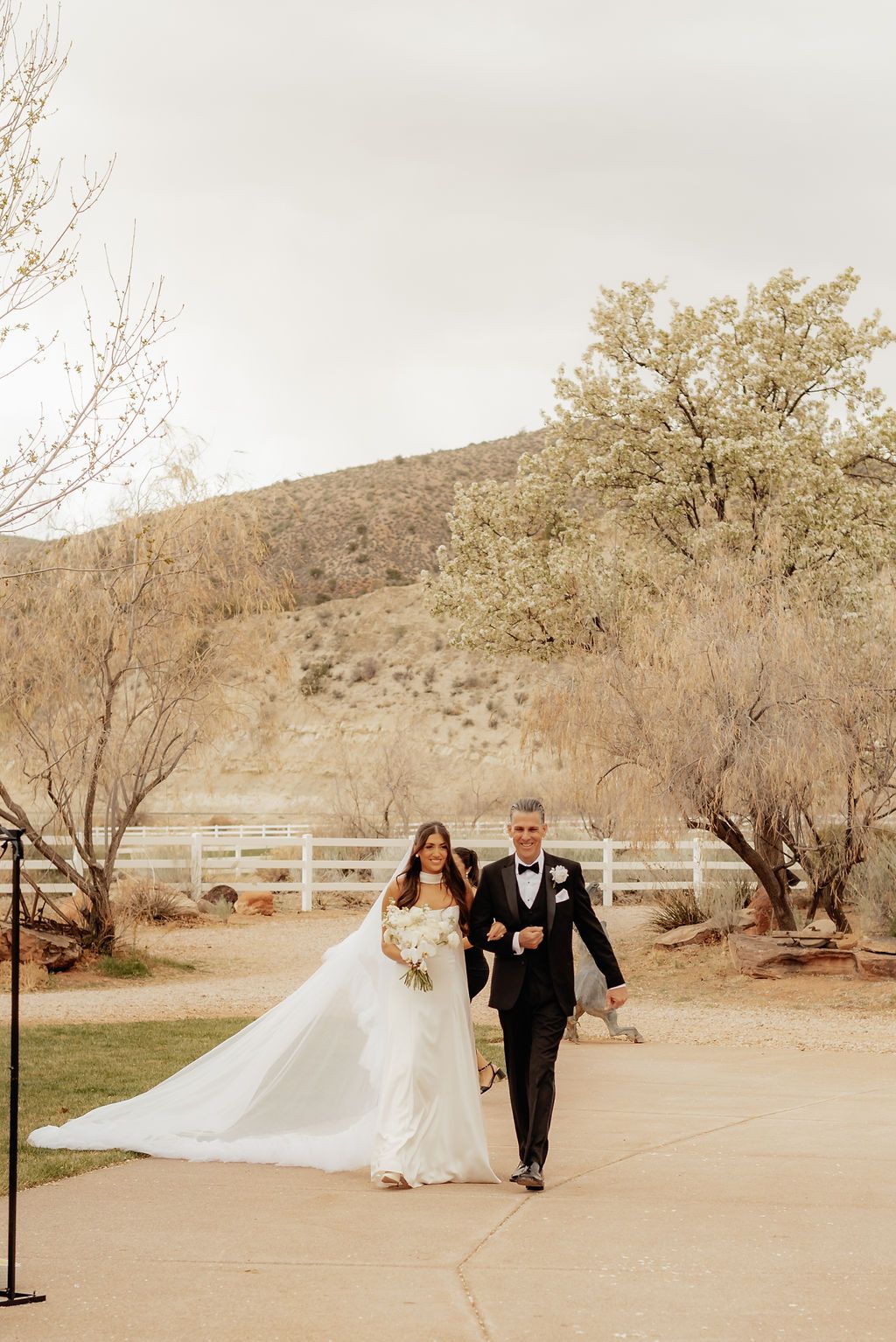 Bride and groom walking hand in hand outdoors in a desert wedding setting