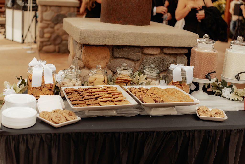 Buffet table with trays of food, cupcakes, and desserts at an event