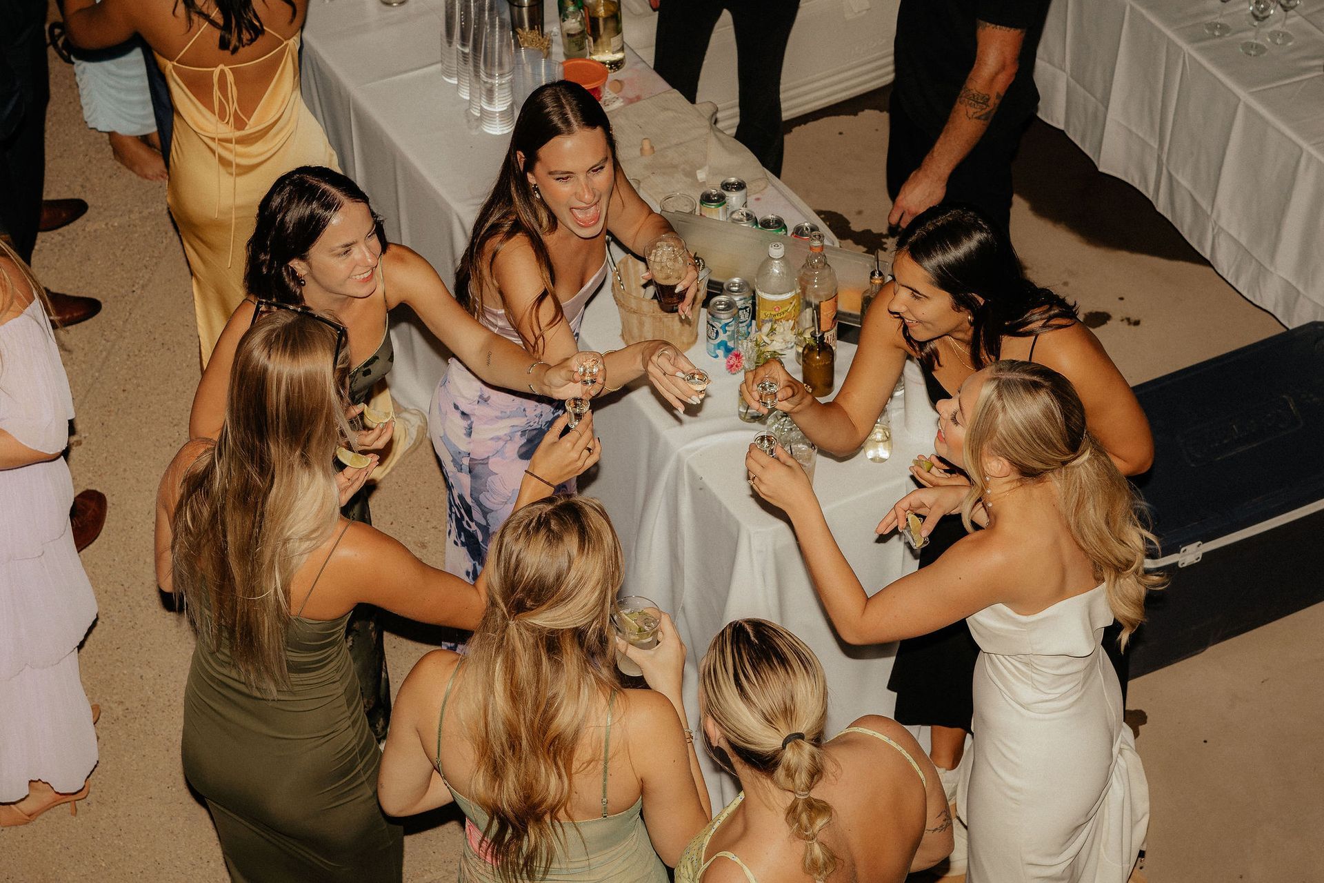 People chatting around a candlelit dinner table with drinks and flowers