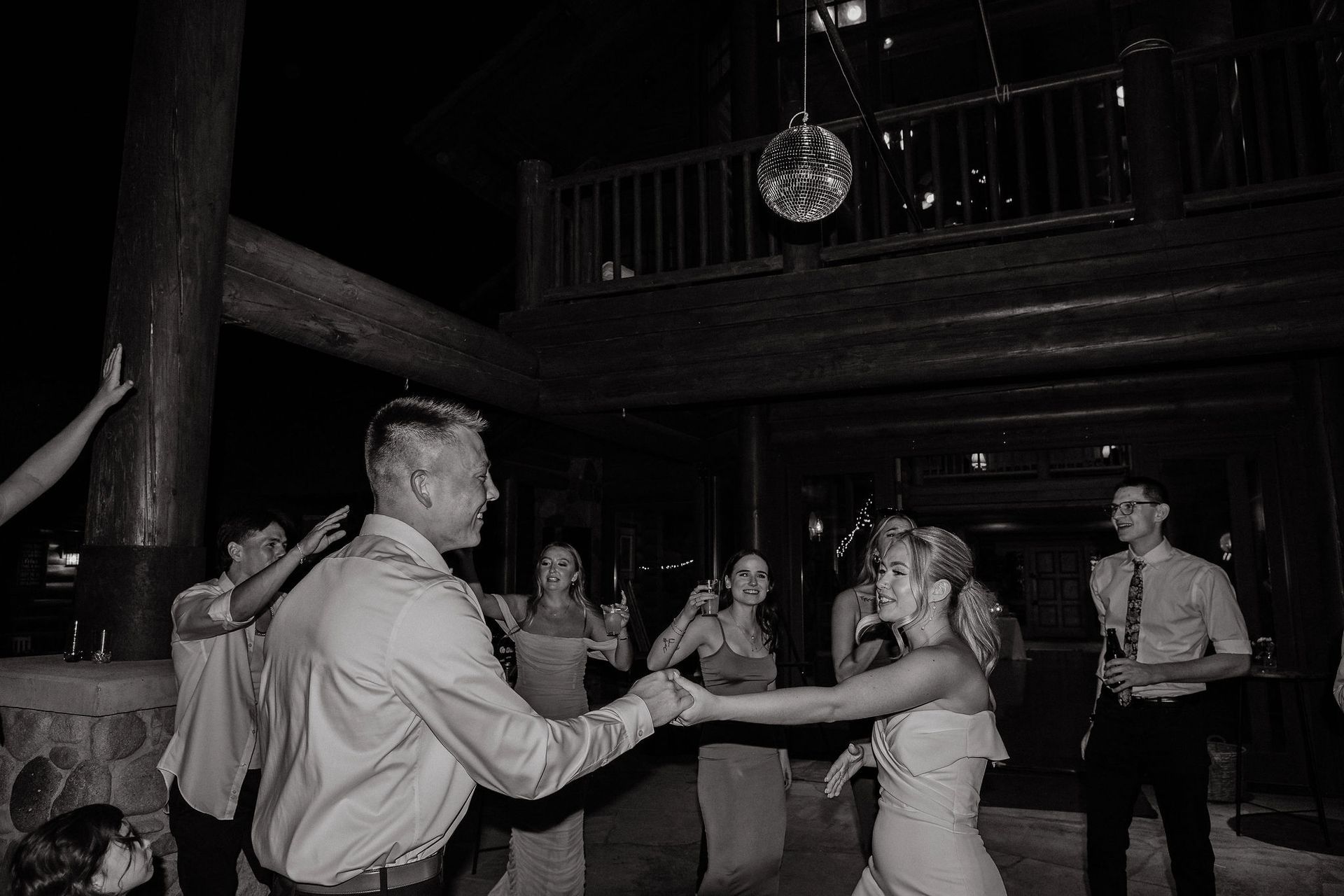 Guests dancing at a dimly lit indoor event under a hanging disco ball