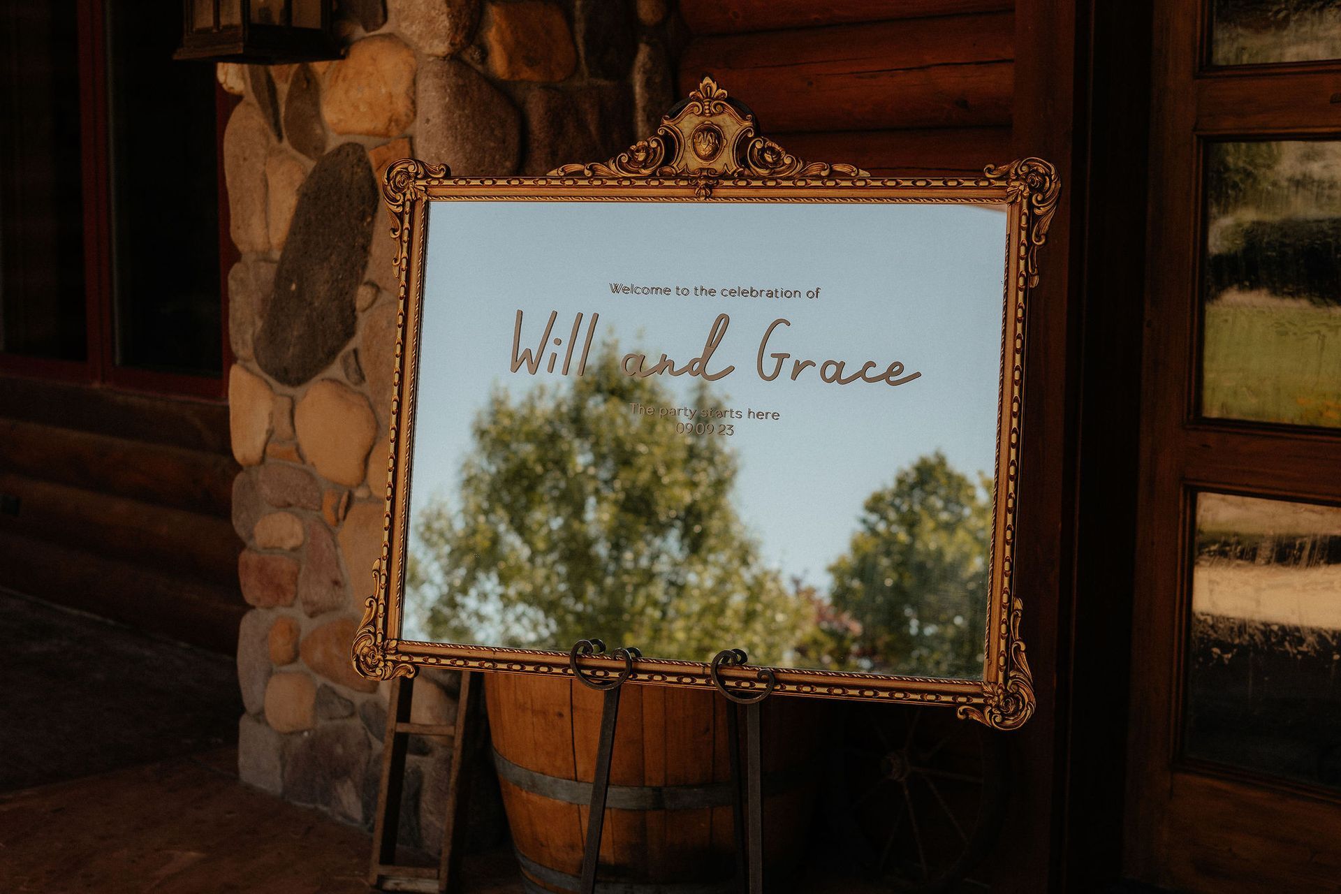 Sign reading “Wild Grace” in a gold frame on a rustic wooden cabin wall