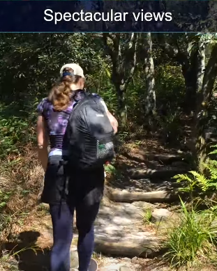 Two hikers walking along a wooded trail with rocky steps under the caption “Spectacular views.”