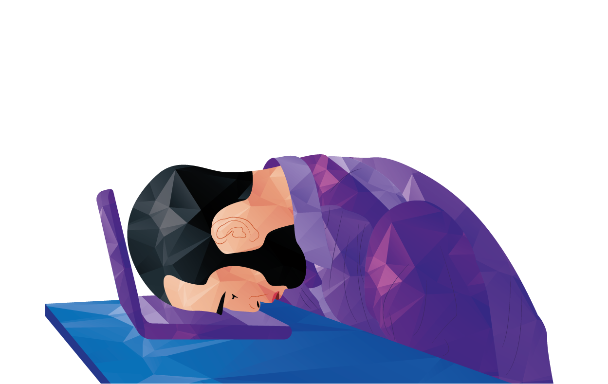 Person sleeping at a desk beside a purple laptop, head resting on folded arms