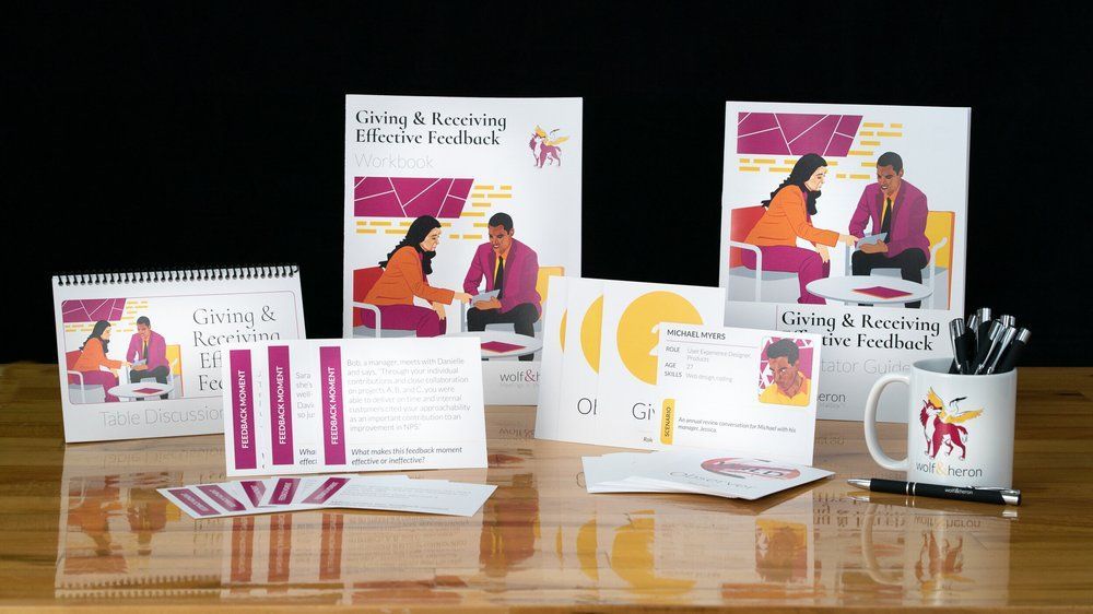 Marketing materials with purple and orange accents, including books, postcards, and a mug.