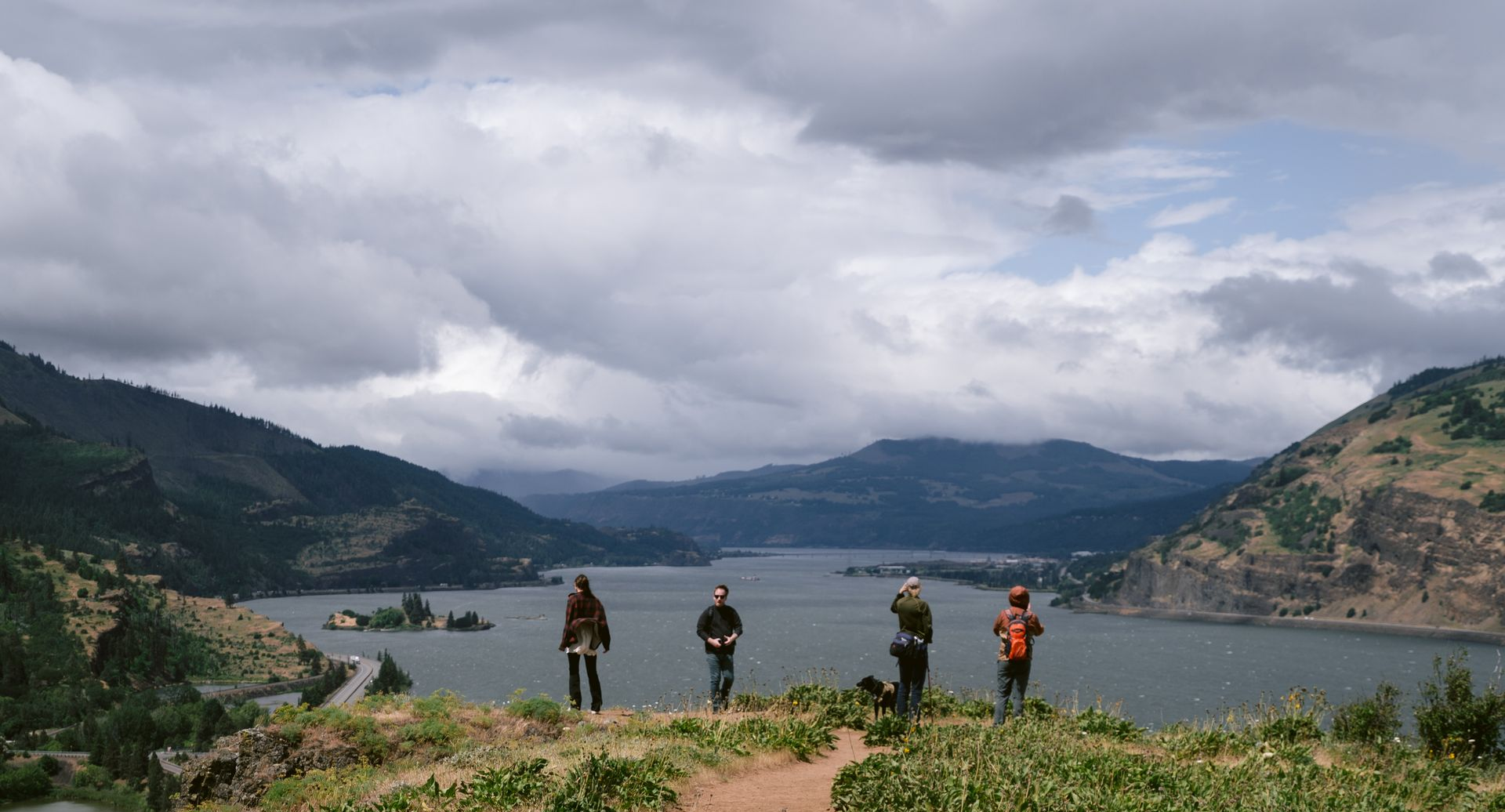 Four community members and a dog look out over the Columbia River Gorge