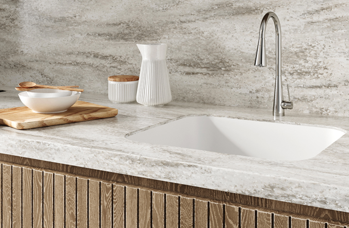 Modern kitchen sink with light stone countertop, wood-front cabinets, and simple decor
